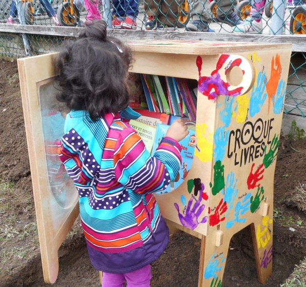 enfant qui déposent un livre dans un Croque-Livres