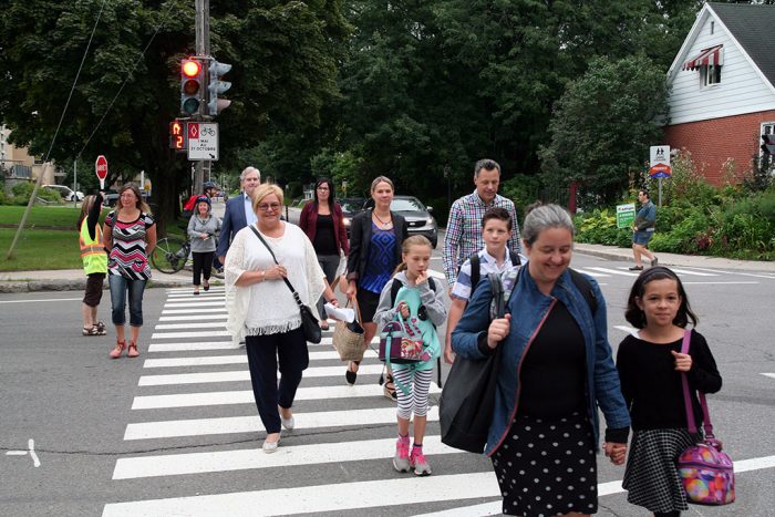 Des écoliers et des élus municipaux traversent une rue dans le quartier Lairet