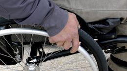 Main sur une roue d'une chaise roulante