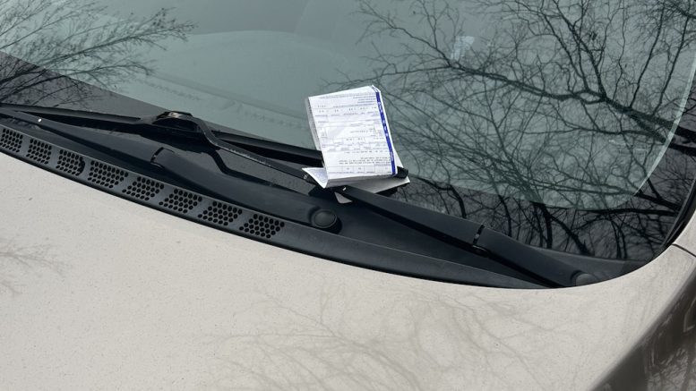 Ticket de stationnement sur le pare-brise d'une auto.